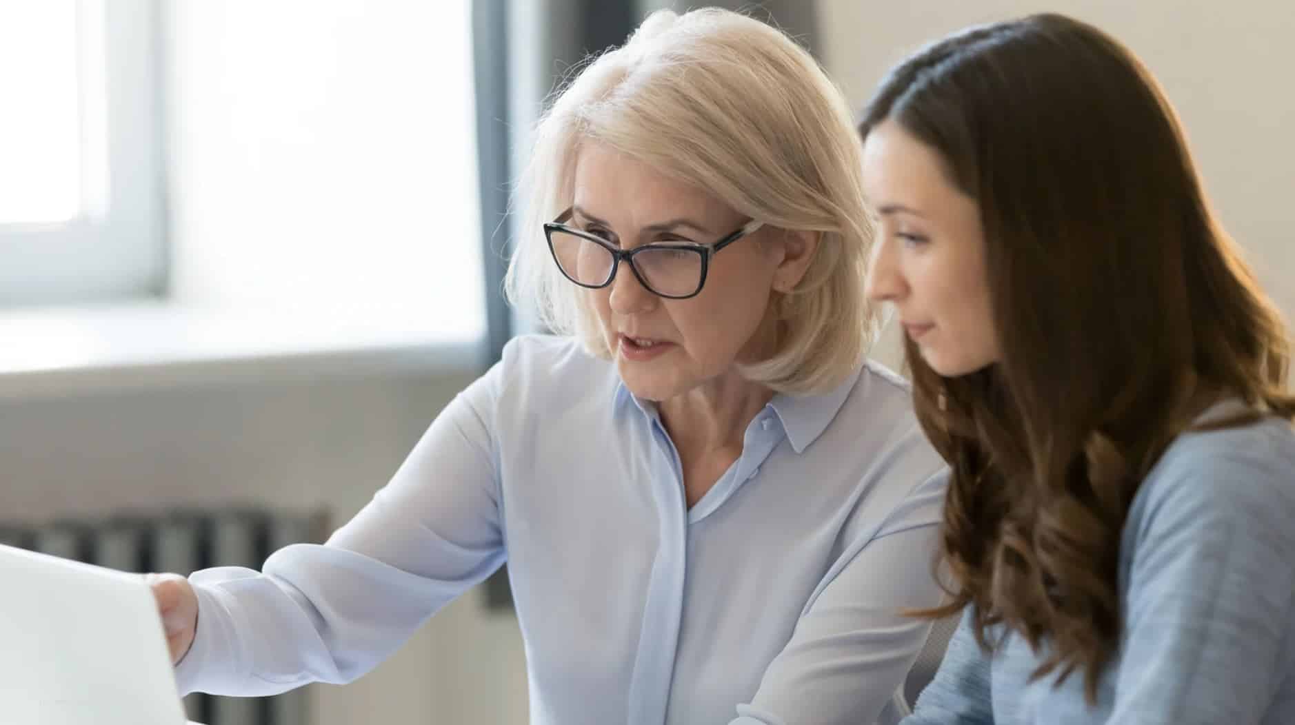 Eine erfahrene und eine junge Frau gemeinsam vorm Laptop