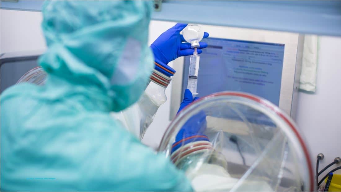 Zytostatika, (c) Canva, VictorCap, Getty Images Person im Schutzanzug zieht Zytostatika-Spritze auf