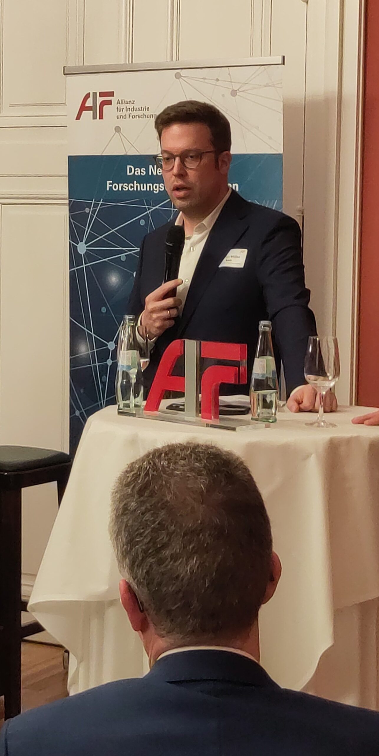 © AIF Florian Müller, MdB, spricht am Stehtisch.