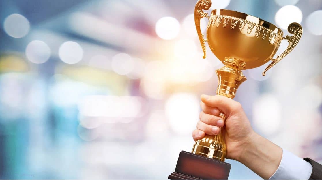 DGMK-Preis, (c) Canva, Billion Images Hand mit goldenem Pokal