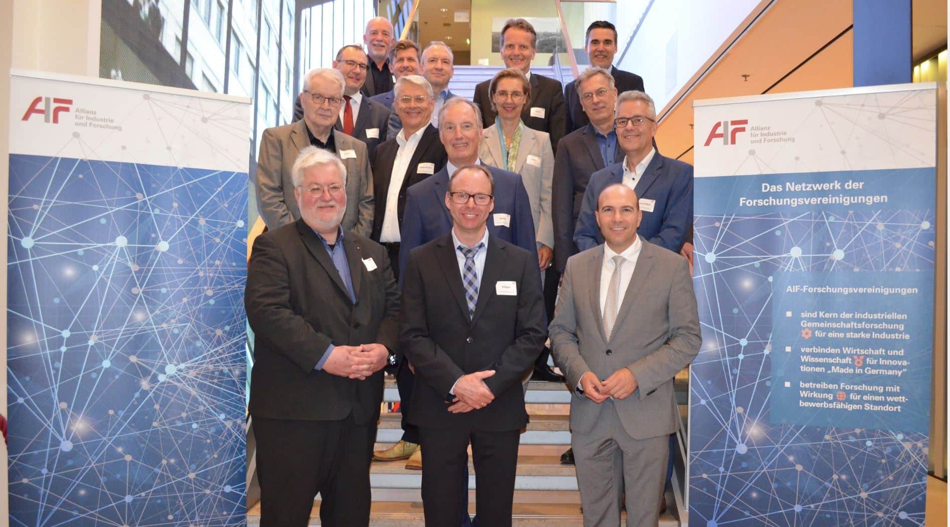 14 Männer und eine Frau stehen für ein Gruppenbild auf der Treppe, rechts und links von ihnen stehen zwei Roll-ups der AIF - Allianz für Industrie und Forschung, Copyright AIF